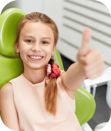 Young dental patient giving thumbs up in dental chair