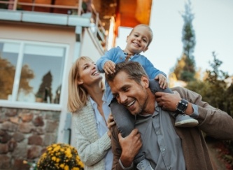 Parents and child smiling together after visiting their dentist in Castleton