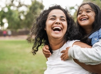 Mother and child laughing together after emergency dentistry visit